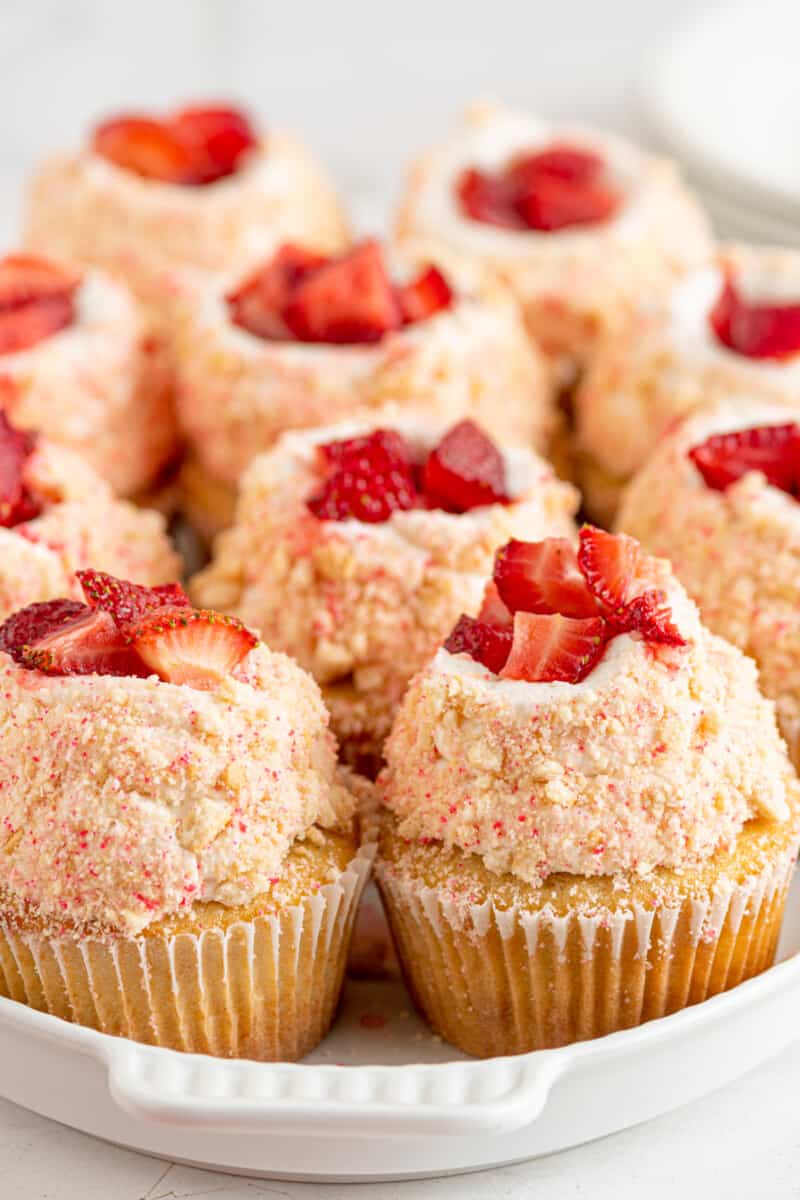 10 strawberry shortcake cupcakes in an oval serving dish.