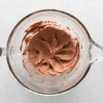 overhead view of chocolate buttercream in a glass mixing bowl.