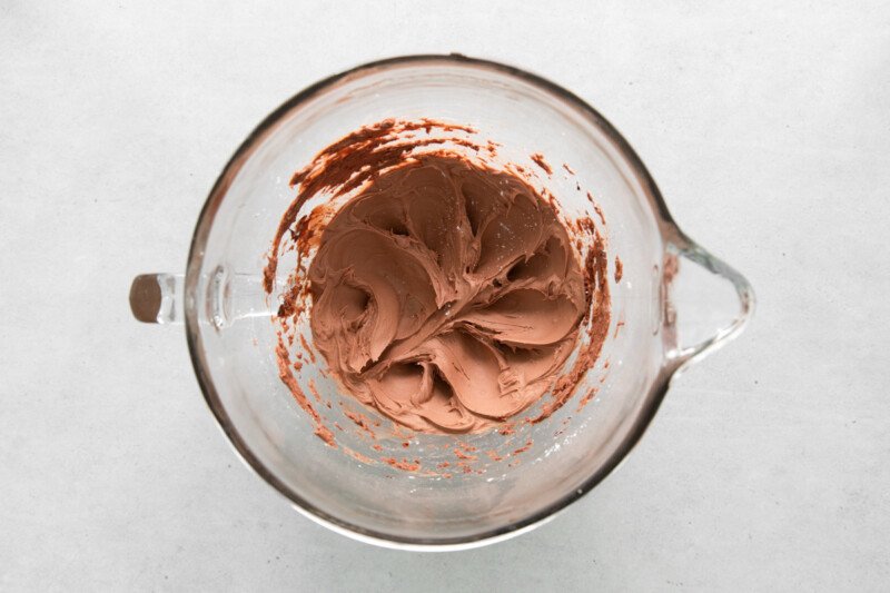 overhead view of chocolate buttercream in a glass mixing bowl.
