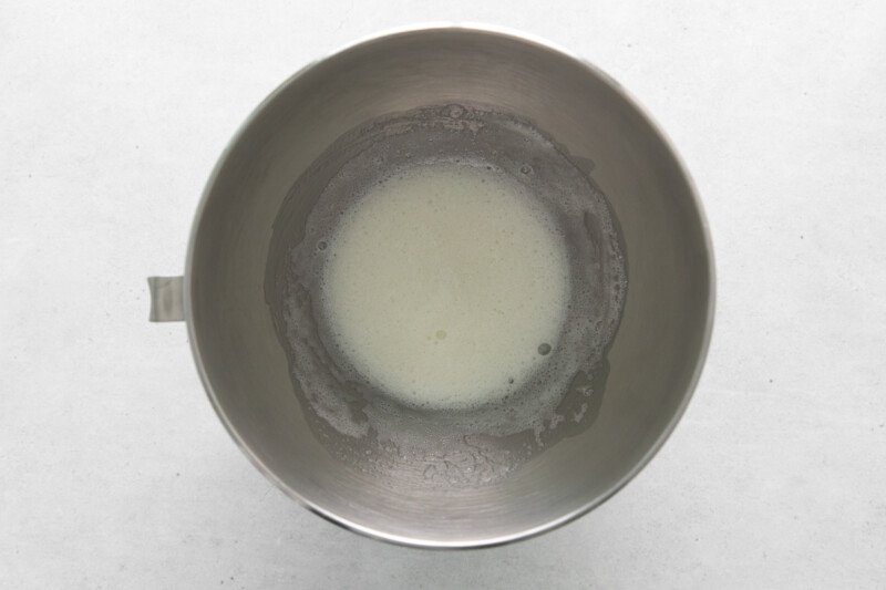 overhead view of egg whites in a stainless mixing bowl.