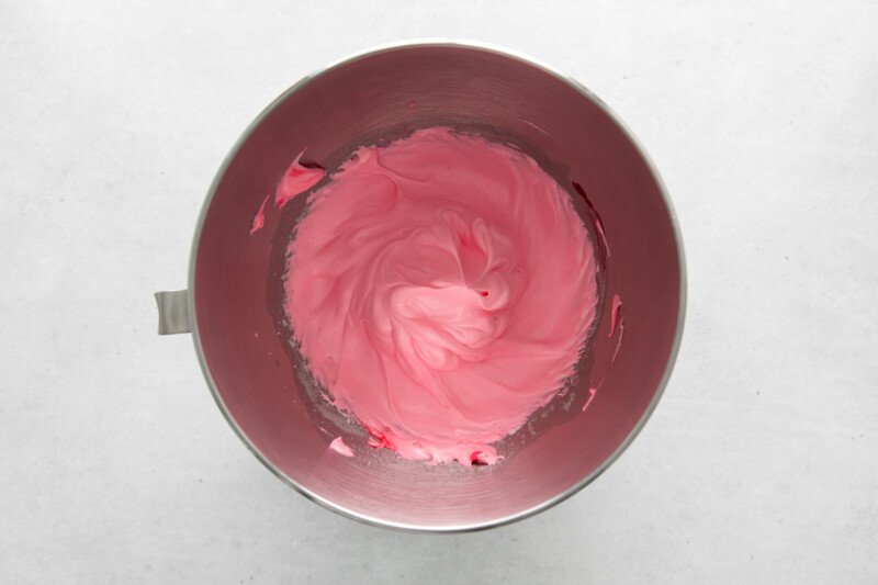 overhead view of pink meringue in a stainless mixing bowl.