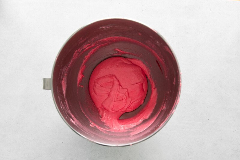 overhead view of folded pink macaron batter in a stainless mixing bowl.