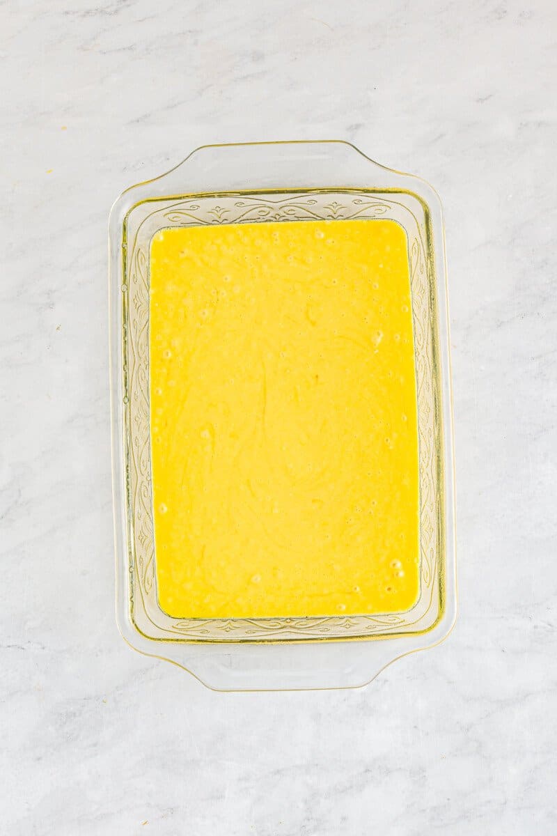 yellow cake batter in a glass baking dish.