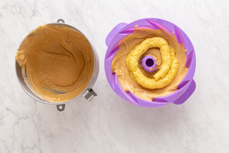 custard filling piped on top of bundt batter in a purple silicone bundt mould.