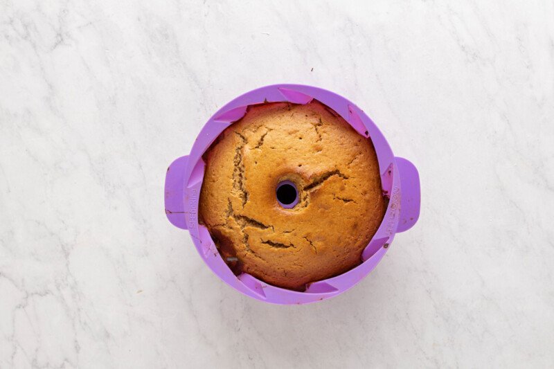 baked churro bundt cake in a purple silicone bundt mould.