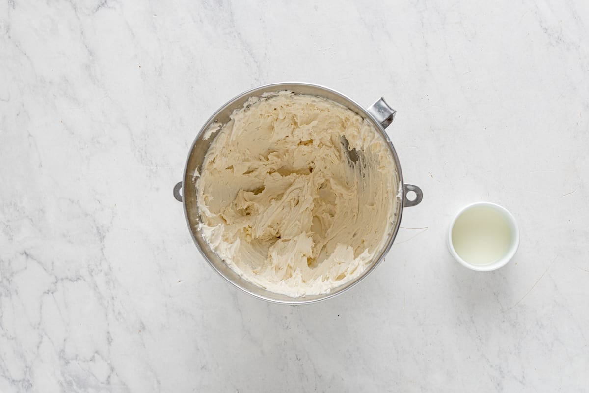 overhead view of buttercream for strawberry shortcake cupcakes in a stainless steel mixing bowl.