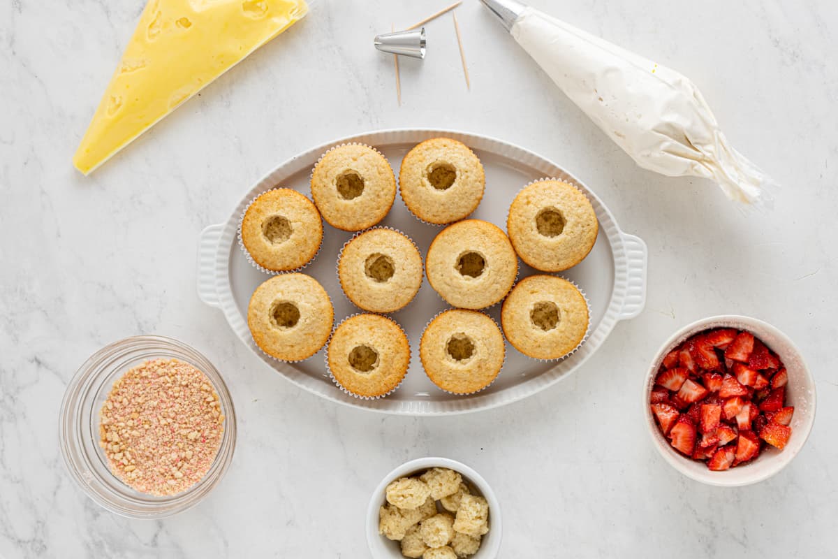 overhead view of 10 hollowed out cupcakes on an oval serving tray.