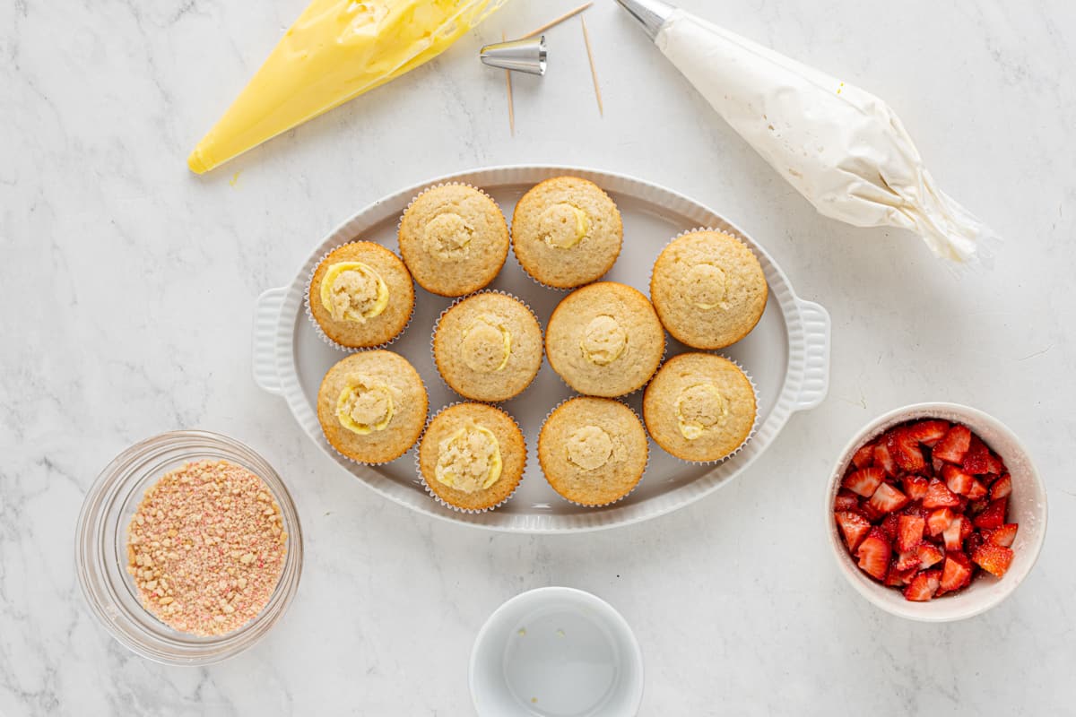 overhead view of pudding filled strawberry shortcake cupcakes on an oval serving tray.