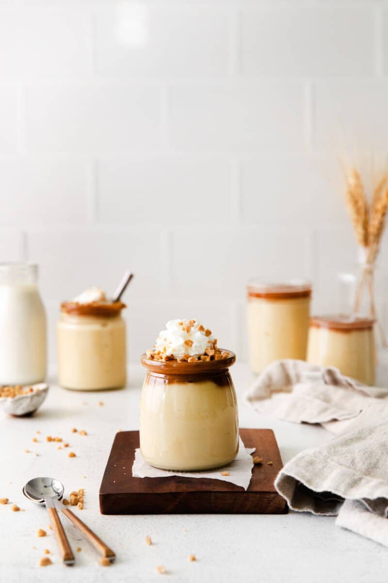 cups of butterscotch pudding with spoons.
