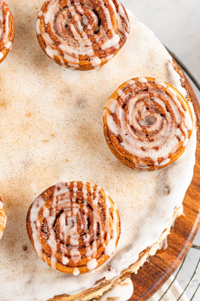 close up of cinnamon roll cheesecake on a wooden platter.
