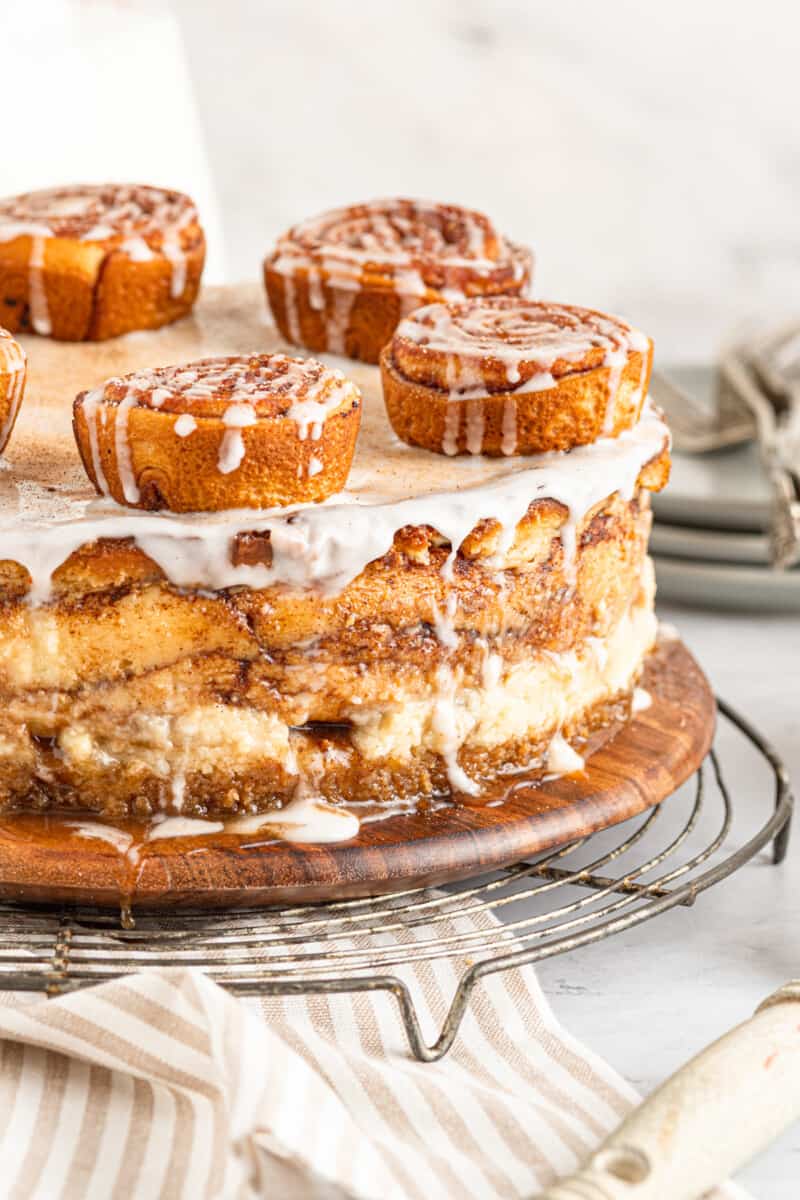 cinnamon roll cheesecake on a wooden platter.
