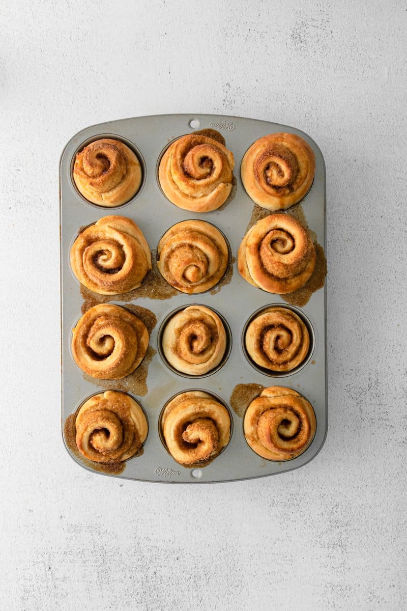 12 cinnamon roll muffins in a muffin tin.