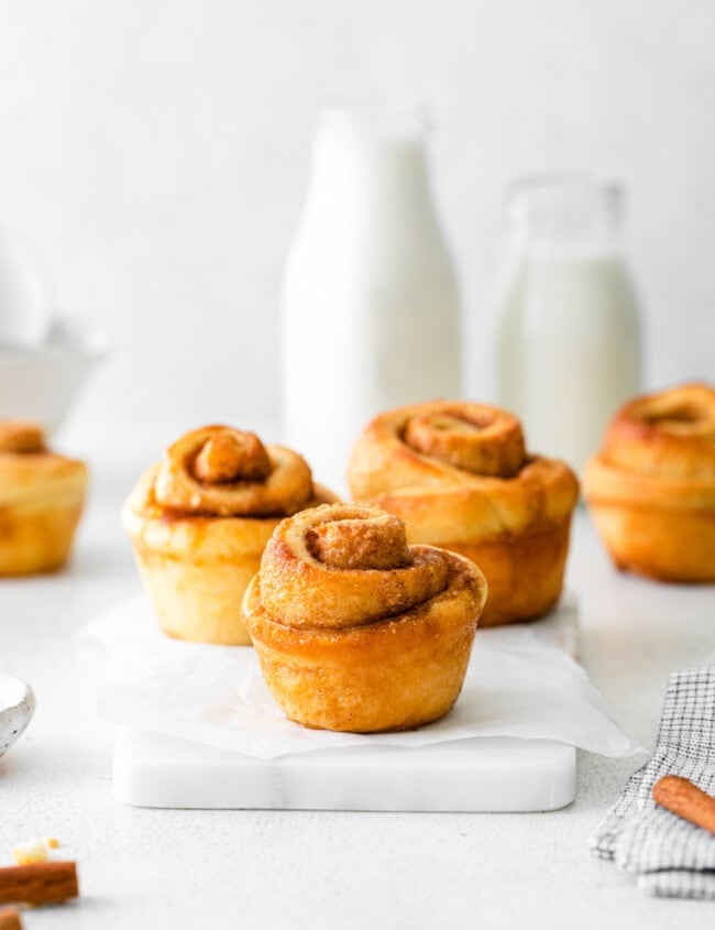 3 cinnamon roll muffins on a marble serving platter.