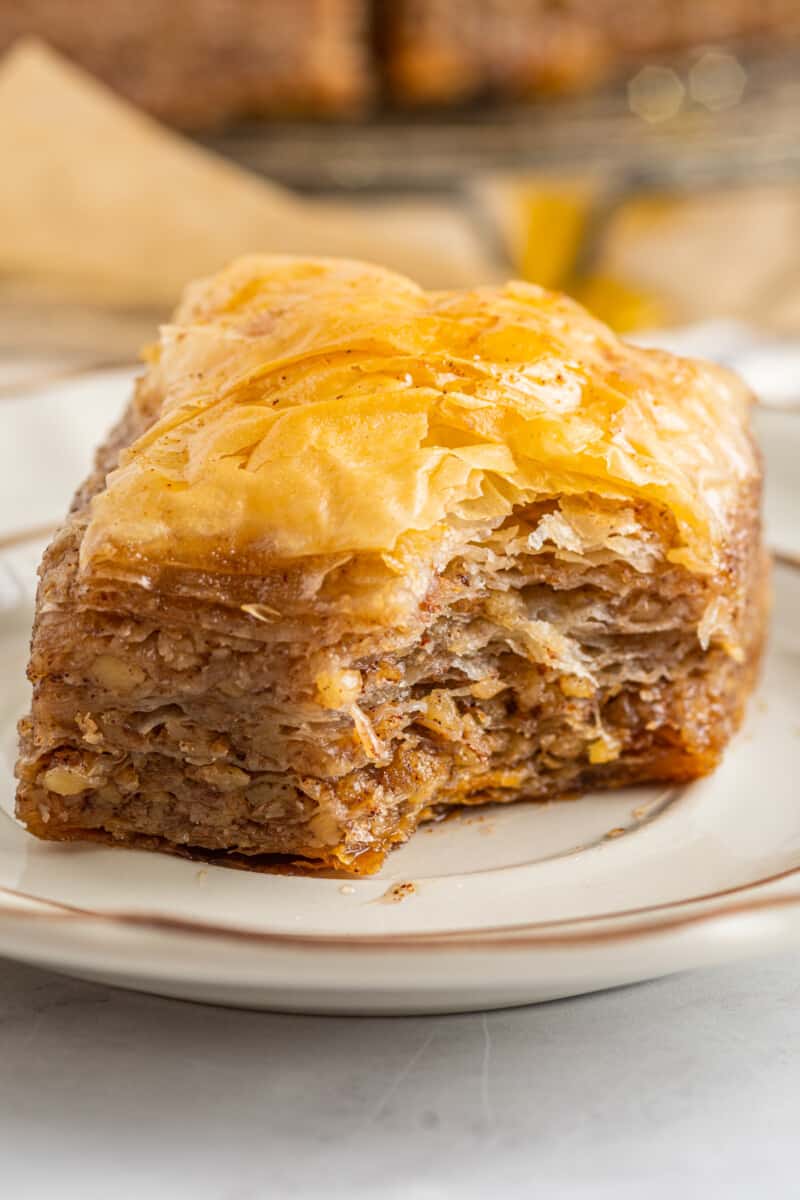 a bitten square of homemade baklava on a white plate.