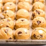 brown butter chocolate chip cookie dough balls on a baking sheet.