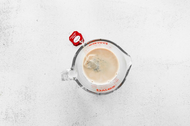 chai tea steeping in milk in a glass bowl.