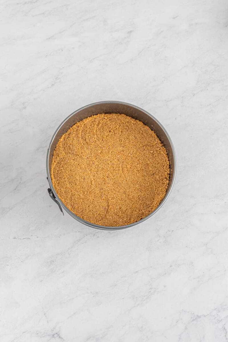 cinnamon roll cheesecake crust in a springform pan.