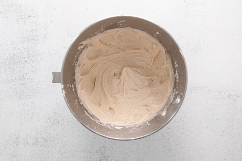 cinnamon swirl cupcake frosting in a stainless mixing bowl.