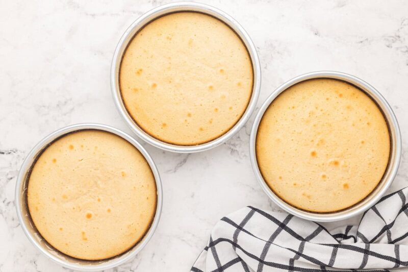 3 baked wedding cake layers in round cake pans.