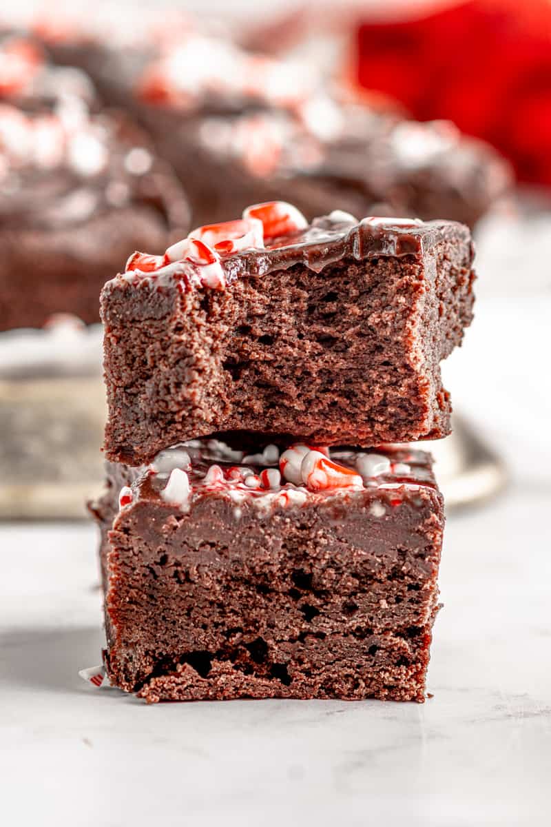 profile view of 1 bitten peppermint brownies stacked on another.