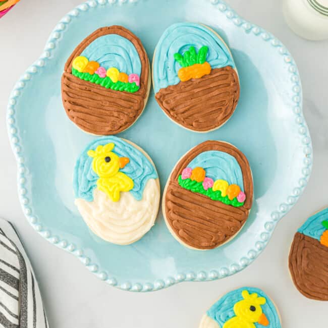 overhead view of 4 easter egg sugar cookies on a blue plate.