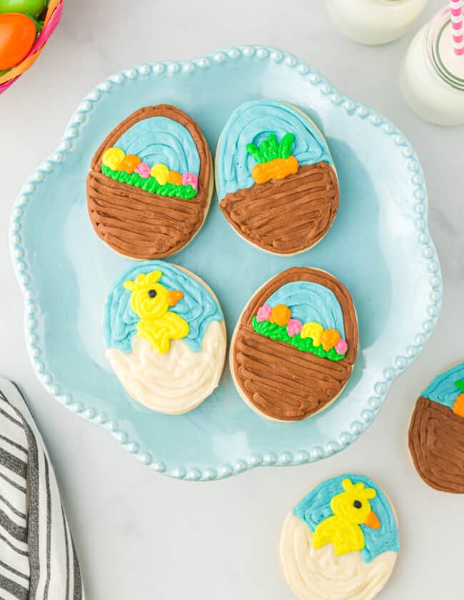 overhead view of 4 easter egg sugar cookies on a blue plate.