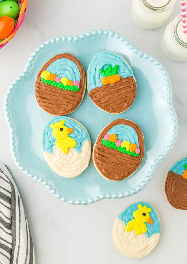 overhead view of 4 easter egg sugar cookies on a blue plate.