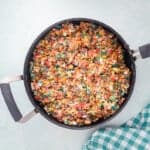 stirred fruity pebbles and marshmallow mixture in a saucepan.