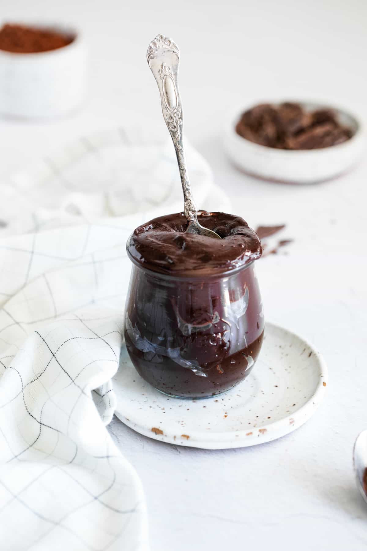 glass jar filled with chocolate hazelnut spread, with a spoon stuck in