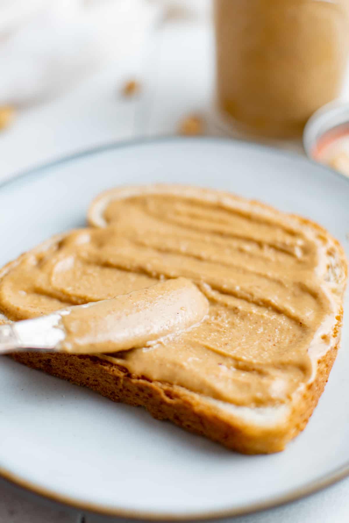 spreading peanut butter onto a piece of toast