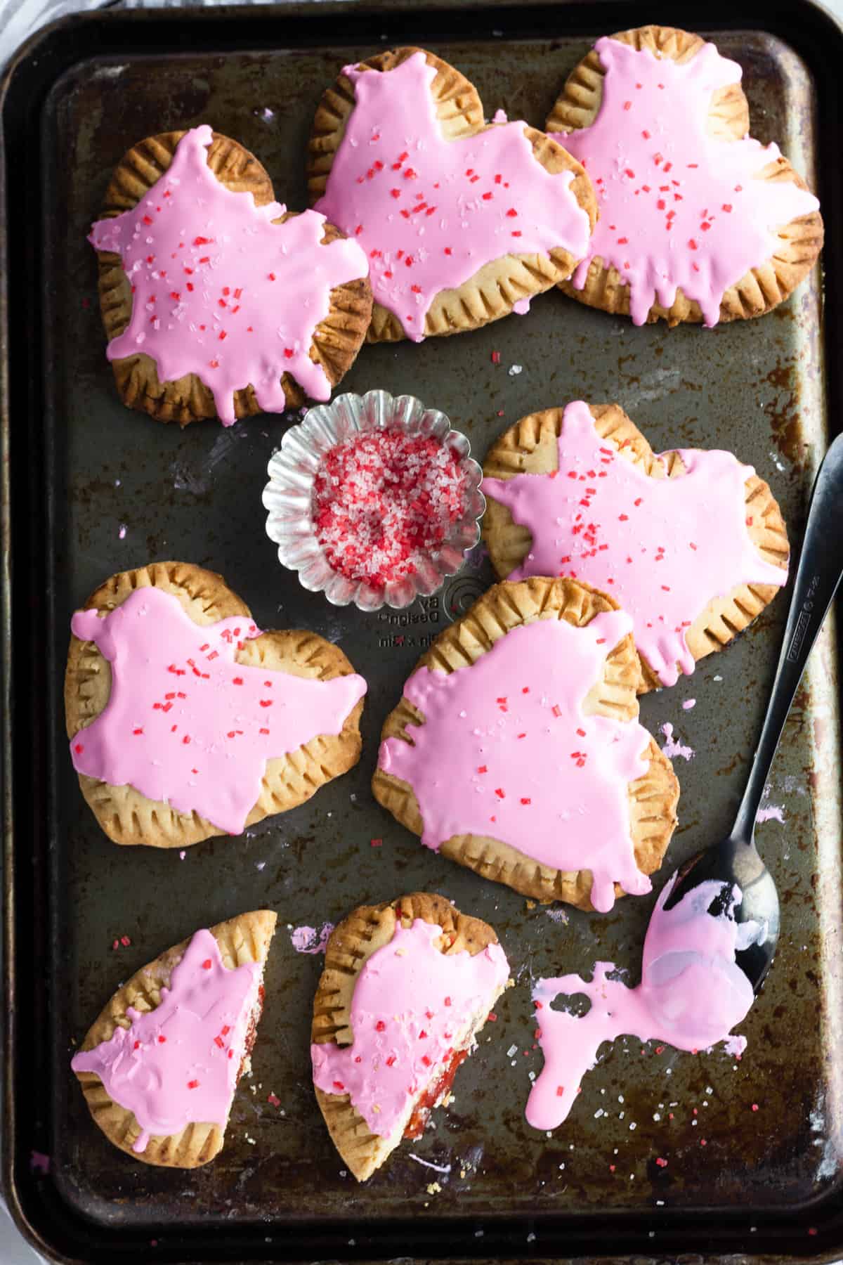 heart-shaped pop tarts on a baking sheet, one cut in half