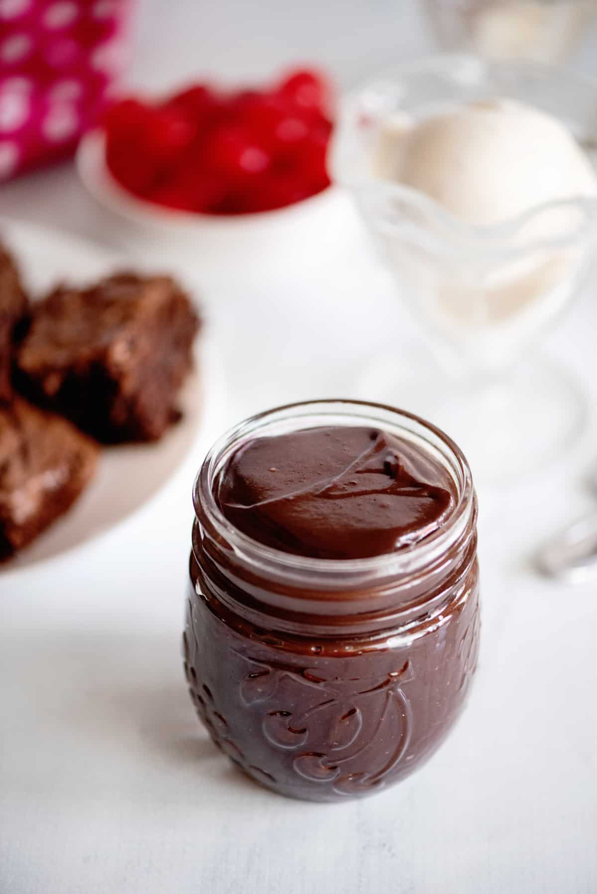 a small glass jar filled with hot fudge