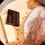 a chocolate bar, a stick of butter, and more hot fudge ingredients assembled in a pot