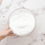 stabilized whipped cream frosting in a glass bowl.
