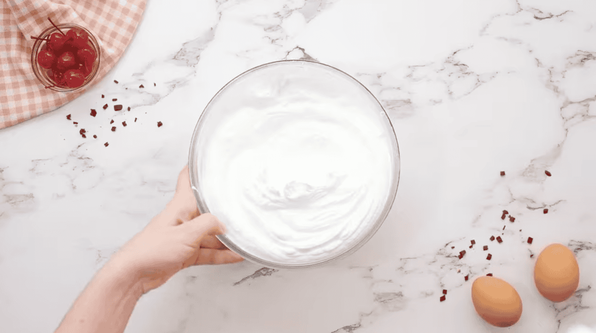 stabilized whipped cream frosting in a glass bowl.
