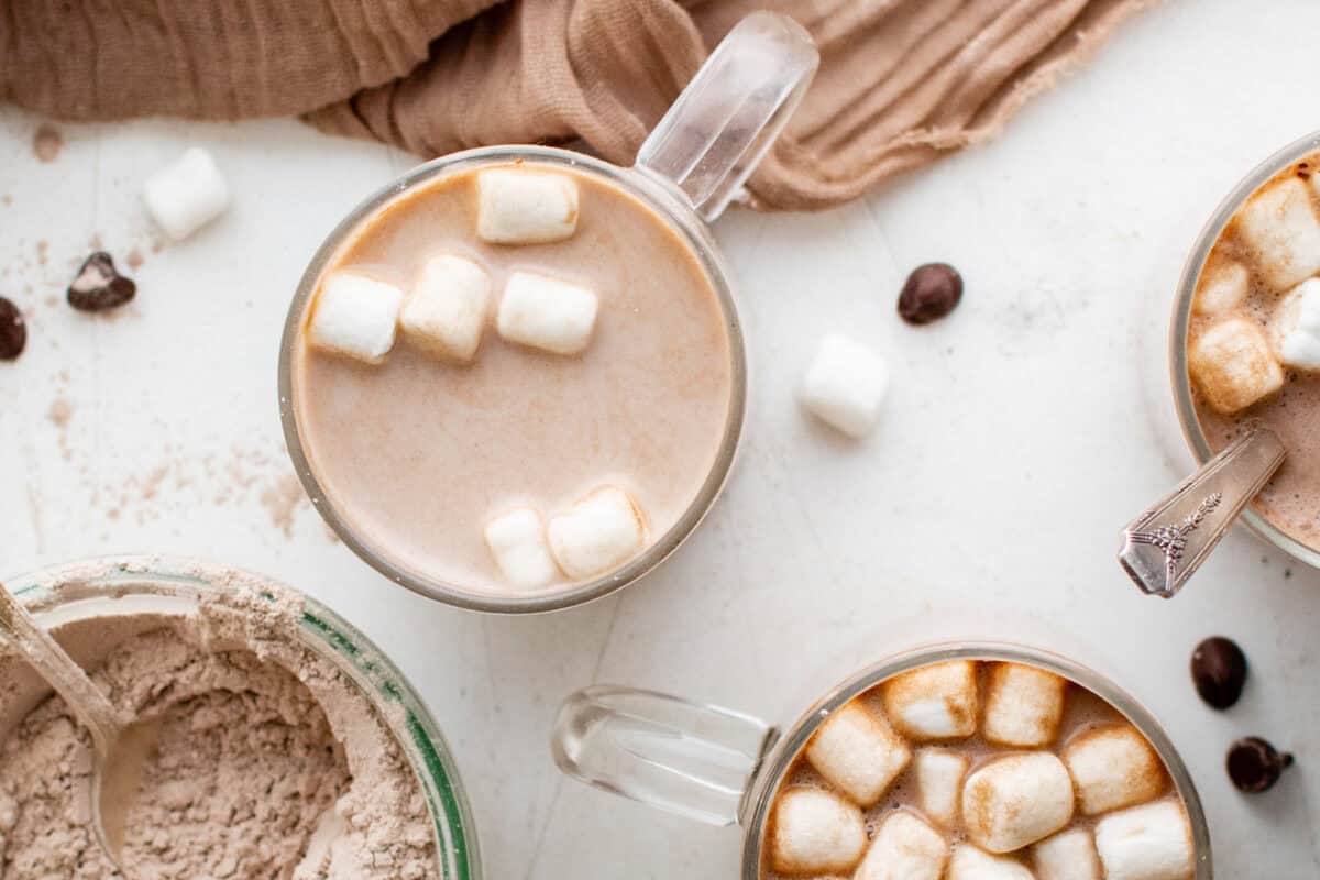 overhead view of prepared homemade hot chocolate in a glass mug with marshmallows.