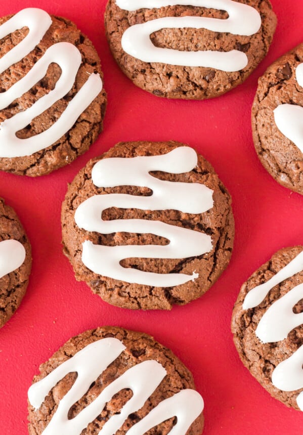 close up of 7 hot cocoa cookies on a red background.