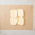 four pieces of butter on a piece of paper.