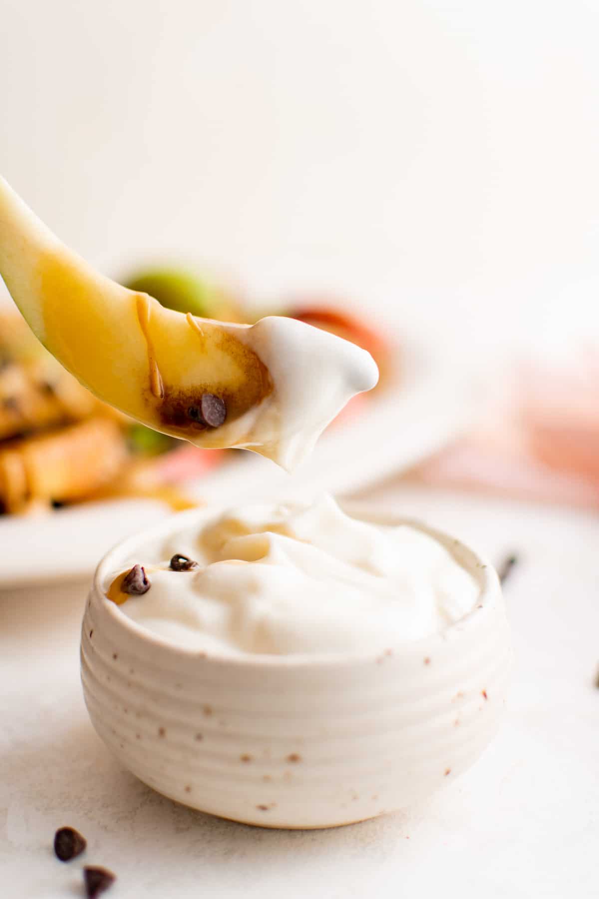 dipping an apple slice in cream cheese fruit dip