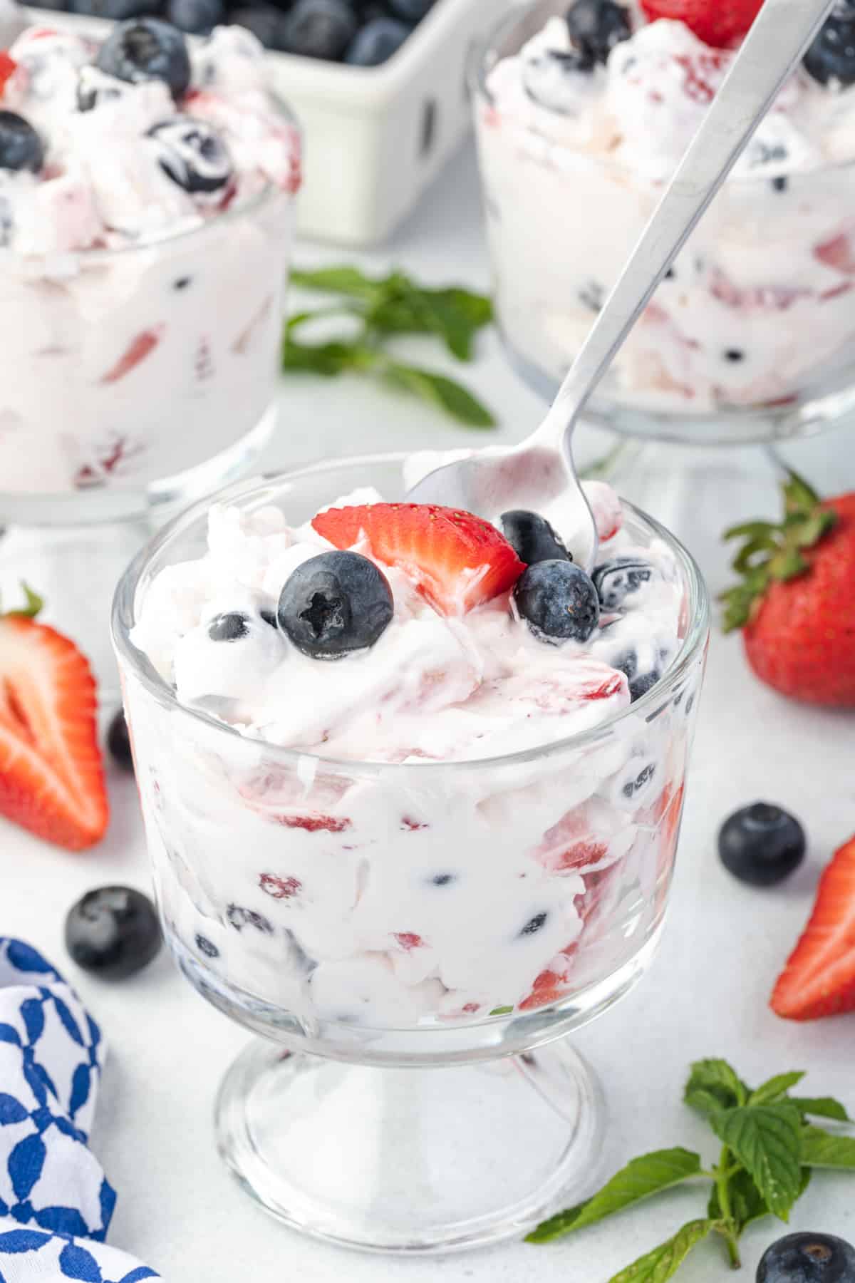 a cup of berry cheesecake salad with a spoon