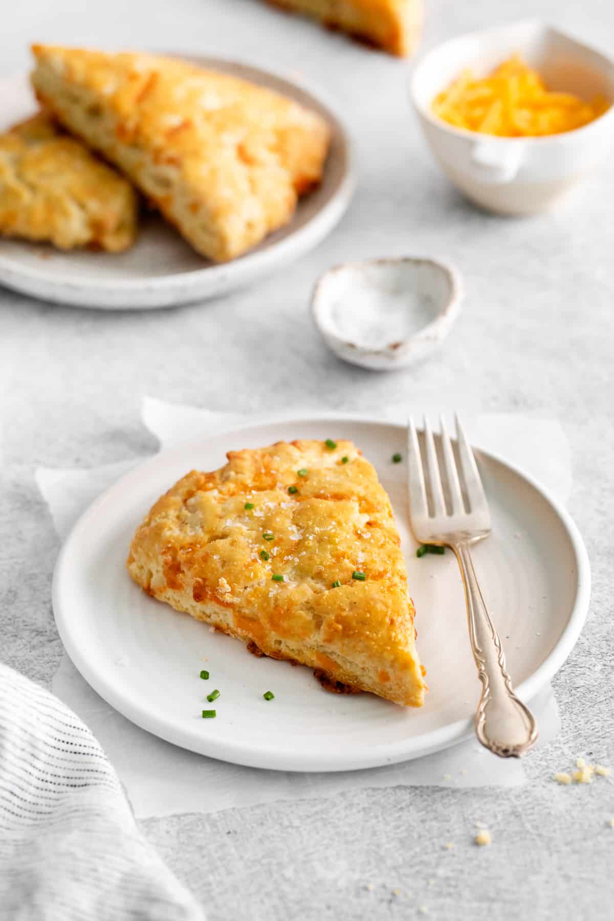 a cheddar scone on a plate with a fork