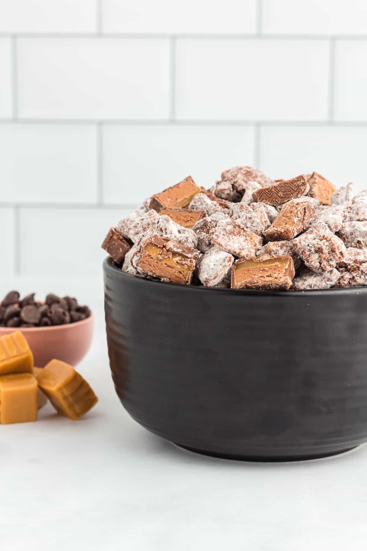chocolate caramel puppy chow in a black bowl