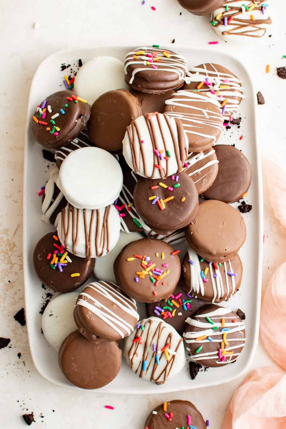 a serving tray stacked high with chocolate dipped Oreos