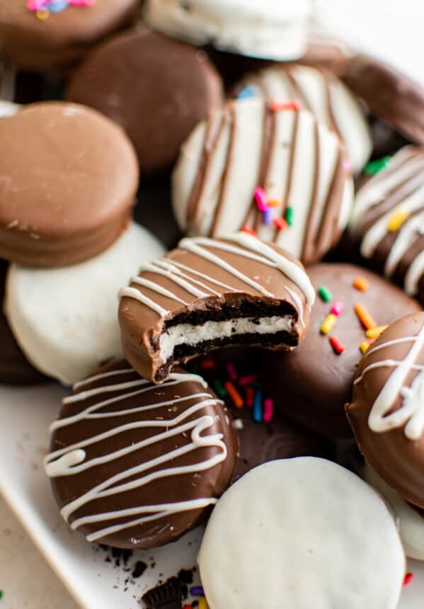 decorated chocolate covered Oreos piled on a serving tray