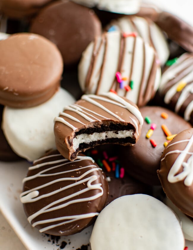 decorated chocolate covered Oreos piled on a serving tray