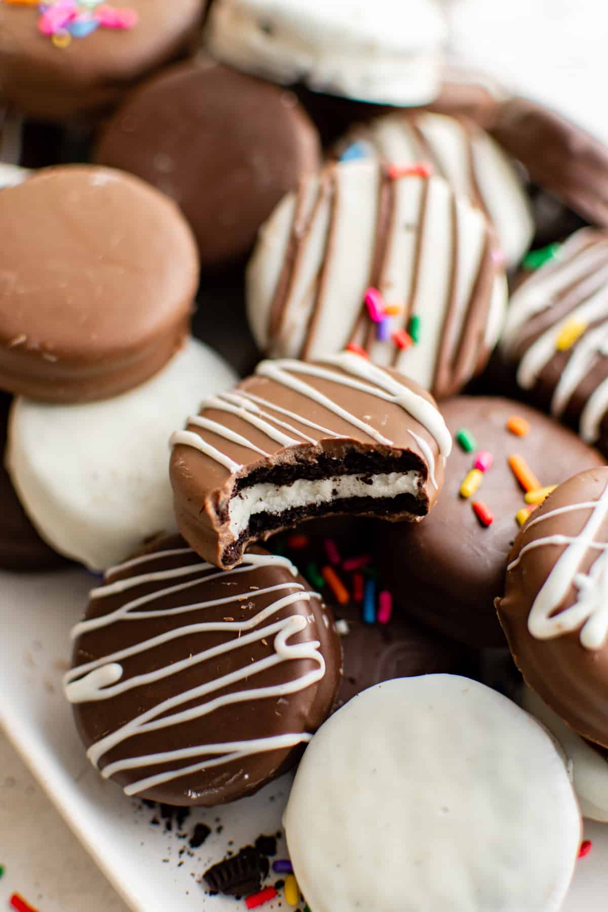 decorated chocolate covered Oreos piled on a serving tray