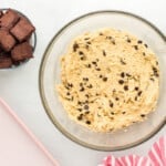 a bowl of chocolate chip cookie dough next to a smaller bowl of brownies cut into cubes