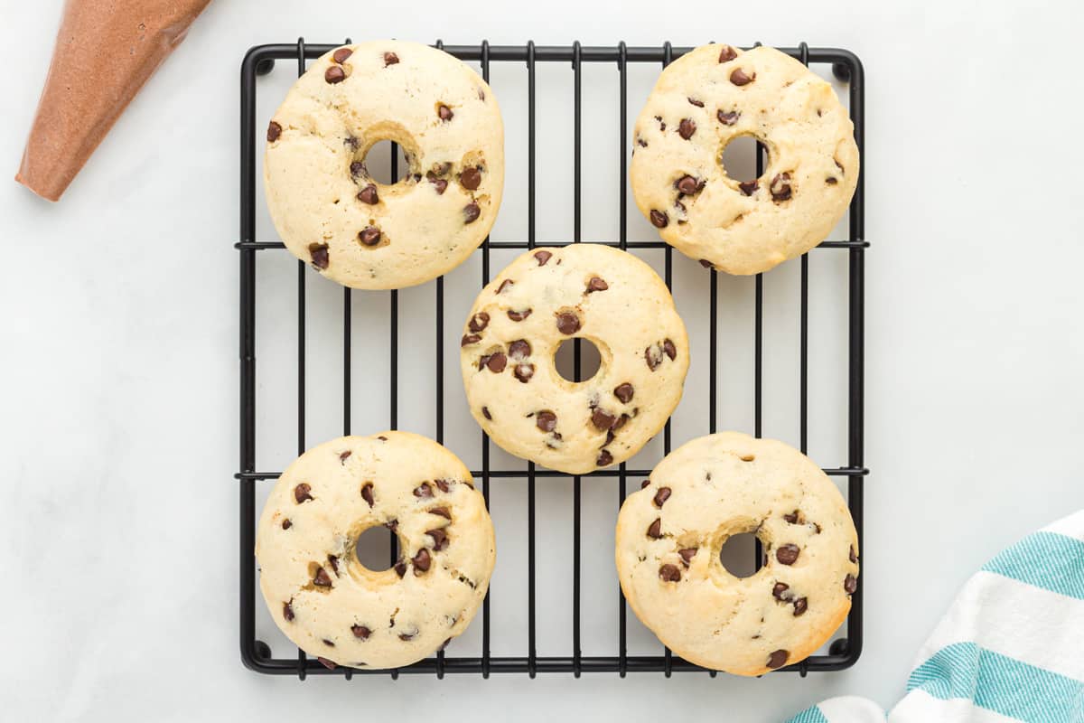 five baked donuts arranged on a cooling rack