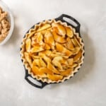 pie in a dish piled up with cooked caramel apple slices