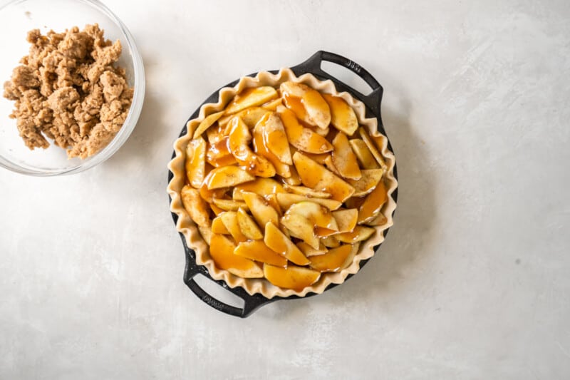 pie in a dish piled up with cooked caramel apple slices